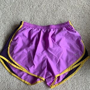 Pink/purple, and yellow/gold Nike running shorts with ties for adjustable waist